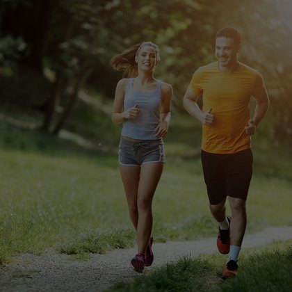 Couple jogging together along a leafy park trail