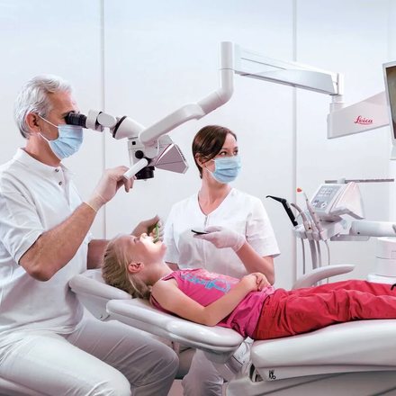 Dental team caring for a young patient in a bright clinic